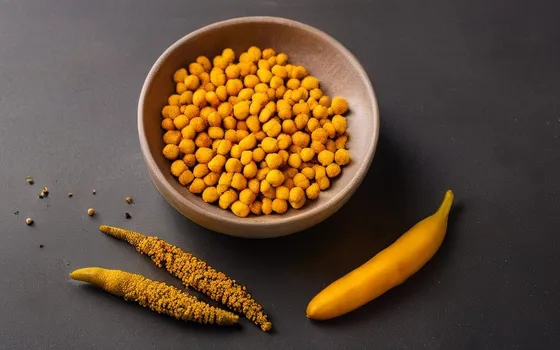 Amber turmeric curcumin capsules in a dish beside fresh turmeric root, ginger and black pepper on a dark surface