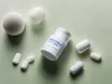 Magnesium capsules and powder beside a supplement bottle on a bright surface