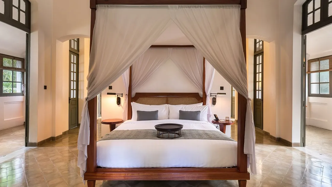 A canopy bed in a dim room at night