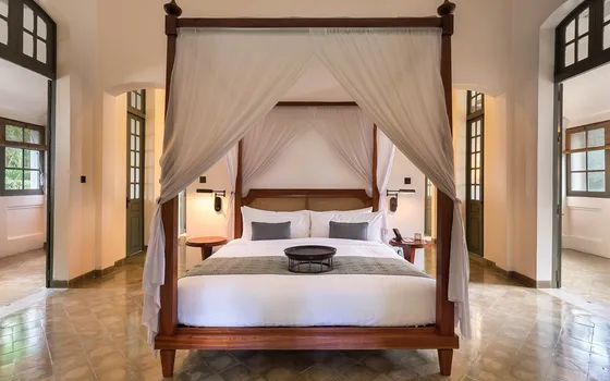 A canopy bed in a dim room at night