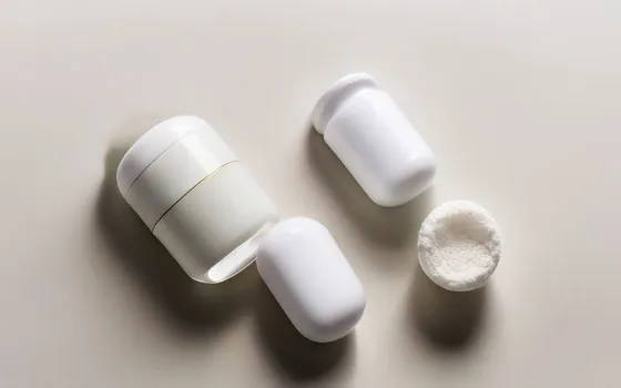 NMN and NR supplement capsules and powder with two bottles on a bright surface