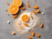 Halved oranges and pieces of orange peel around a heap of pale granular powder on a grey concrete surface, seen from above