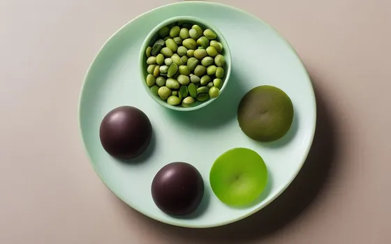 Supplement capsules beside natto, green tea, kiwi and dark chocolate on a minimalist surface